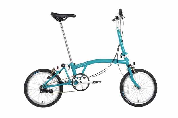 A photography of a light blue Brompton folding bicycle on a white background