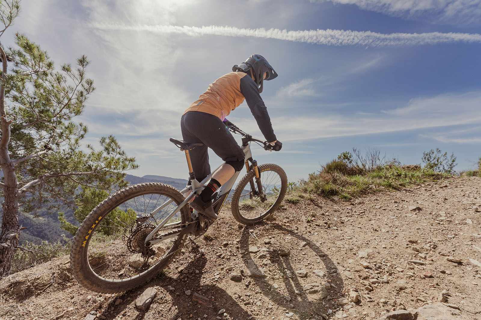Cyclist in orange top riding the Orbea Wild M-Team full suspension mountain eBike